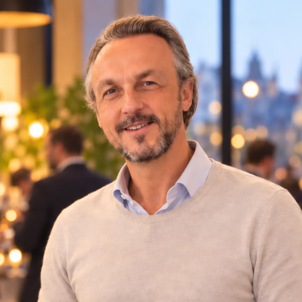 Nicolas Van Caemerbeke, coach professionnel et dirigeant depuis 23 ans, souriant, en pull clair sur chemise bleu ciel, lors d'une soirée professionnelle