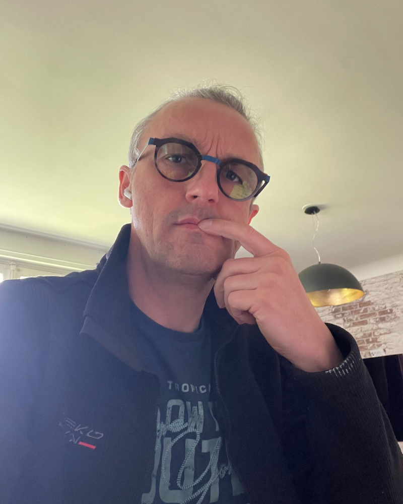 Nicolas Van Caemerbeke, pensif, un doigt posé sur les lèvres, en selfie dans un intérieur.